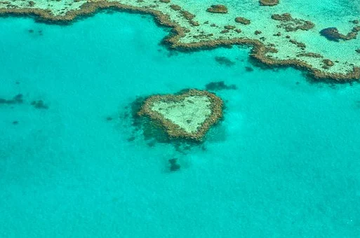 une ile en forme de cœur au milieu d'une mer turquoise